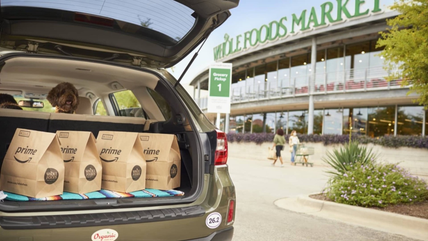 Amazon Prime grocery bags in a car trunk at a Whole Foods Market pickup spot